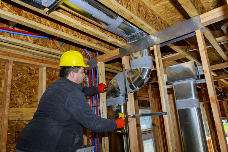 Sharpsburg HVAC contractor making final air duct conditioning HVAC system ventilation pipes stands for heating